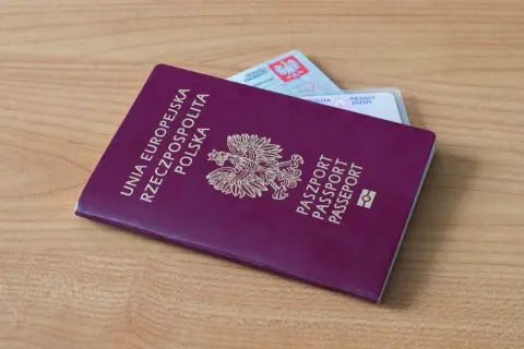 Polski paszport i dowód osobisty leżą na drewnianym stole. Czy na Wyspy Kanaryjskie potrzebny jest paszport? Tak, jeśli nie podróżujesz na dowód.