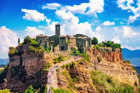 Antico centro storico su una rupe, con un ponte pedonale che conduce al borgo.