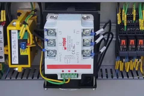 Wewnątrz szafy sterowniczej widoczny jest trójfazowy przekaźnik SSR marki Relpol, otoczony przewodami i innymi elementami elektrycznymi.