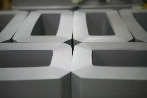Część rdzenia transformatora, ułożone obok siebie metalowe elementy tworzące kształt litery "E".