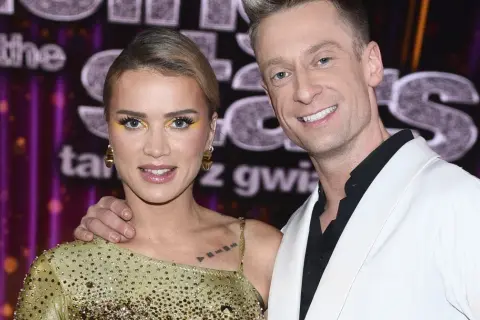 Maffashion i Danilczuk uśmiechają się do kamery. Ona w złotej sukience, on w białej marynarce.