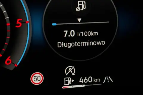 Na desce rozdzielczej widać wskaźnik paliwa, prędkościomierz i ikonę drogi. Długoterminowe spalanie to 7.0 l/100km. Zasięg 460 km. Czas start stop.