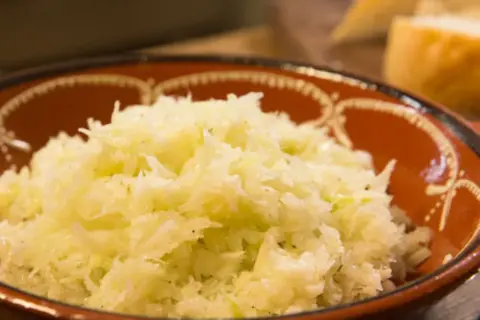 Ein rustikaler griechischer Krautsalat in einer Terrakotta-Schale, appetitlich und frisch zubereitet.