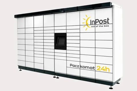 Największa skrytka InPost, Paczkomat 24h, z mnóstwem białych drzwiczek i centralnym panelem.