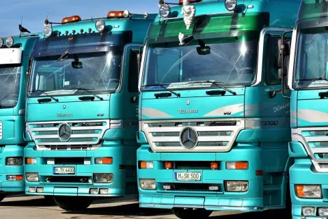 Varios camiones Mercedes-Benz Actros turquesas en fila. ¿Cuántos litros de aceite lleva un camión? Depende del modelo, pero estos gigantes pueden necesitar entre 20 y 40 litros.