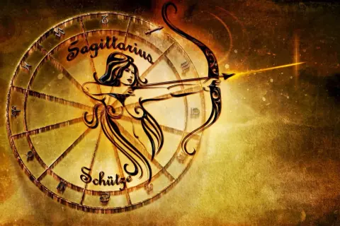 Znak zodiaku Strzelec, symbolizowany przez łucznika z łukiem i strzałą, w złotej oprawie zodiakalnego koła.