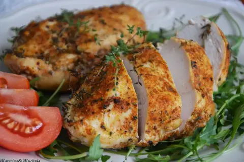 Soczysty filet z kurczaka z piekarnika, przyprawiony ziołami, podany z pomidorami i rukolą.