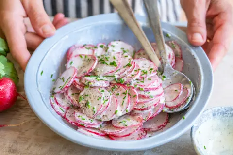 Frischer Radieschen Salat mit Schnittlauch und einer cremigen Soße, bereit zum Servieren.