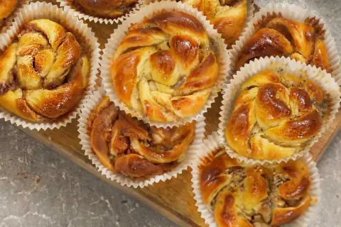Nybakade bullar med mandelmassa och vallmofrön, gyllene och glansiga i sina pappersformar.