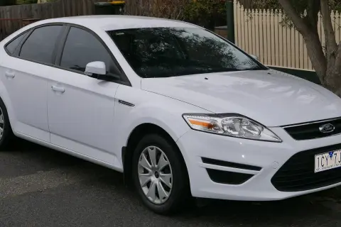 Biały Ford Mondeo MK4, często chwalony w opiniach za komfort i przestronność, zaparkowany na ulicy.