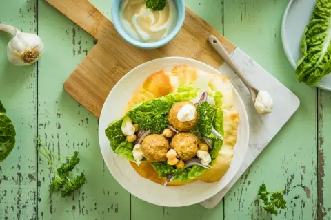 Jak przygotować sos tahini do sałatek i falafeli? Proporcje wody są kluczowe dla idealnej konsystencji. Falafel w picie z sałatą, ciecierzycą i sosem.