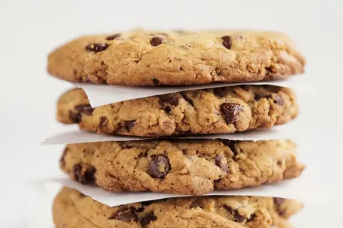 Stapel von vier saftigen Chocolate Chip Cookies, perfekt für Ihr nächstes Rezept.