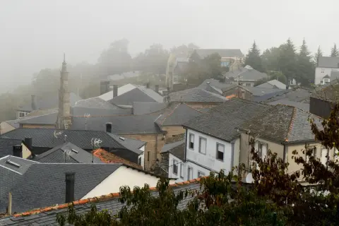 Tejado de pizarra en un pueblo de Manzaneda, Galicia, envuelto en niebla.