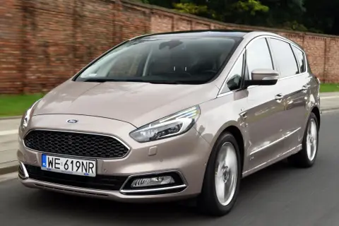 Beżowy Ford S-Max w ruchu. Wiele osób szuka ford s max opinie, ten model wygląda na komfortowy i przestronny.