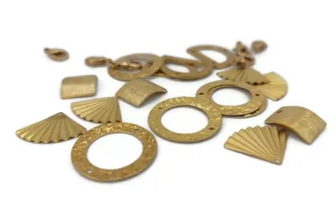 Diverses breloques en laiton aux formes variées : éventails, carrés, cercles texturés. Idéal pour la création de bijoux, leur laiton utilisation est multiple.