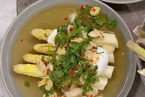 Vit sparris i en ljus buljong, toppad med färska örter, chili och vitlök. En delikat rätt som hyllar vårens smaker.