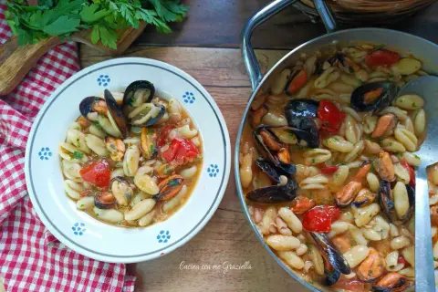 Un piatto invitante di cavatelli cozze e fagioli, con pomodorini e prezzemolo fresco. Un sapore di mare e terra.