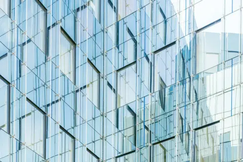 Nowoczesna fasada budynku z tafli szkła, przypominająca wytrzymałość **gorilla glass**.