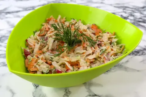 Pyszna surówka z kalarepy z marchewką i koperkiem, podana w zielonej misce.