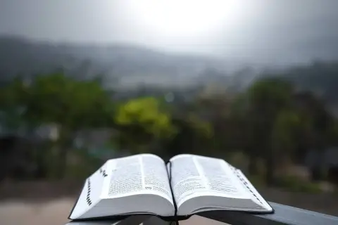 Otwarta księga na tle mglistego krajobrazu. Wartościowe zmiany cytaty inspirują do refleksji.