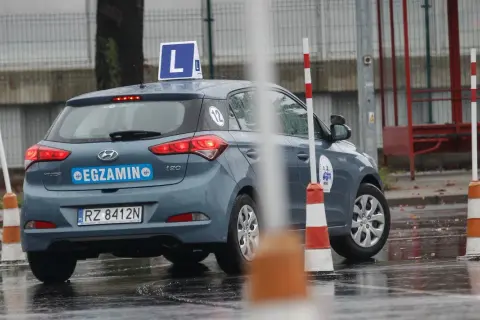 Szary Hyundai i20 z literą "L" na dachu i napisem "EGZAMIN" na klapie, gotowy do jazdy próbnej.