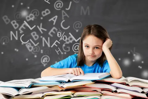 Een meisje met een vermoeide blik zit achter een stapel boeken, omringd door zwevende letters. Ze heeft duidelijk moeite met begrijpend lezen.