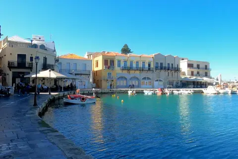 Port w Chanii, Kreta. Wschodnia czy zachodnia część wyspy? Widać kolorowe budynki, łodzie i turkusową wodę.