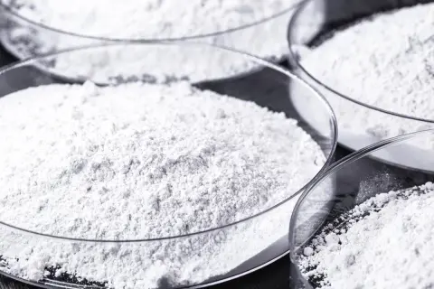 Polveri bianche in capsule di vetro. Il calcio carbonato a cosa serve? È un ingrediente comune in molti prodotti, dall'edilizia alla farmaceutica.