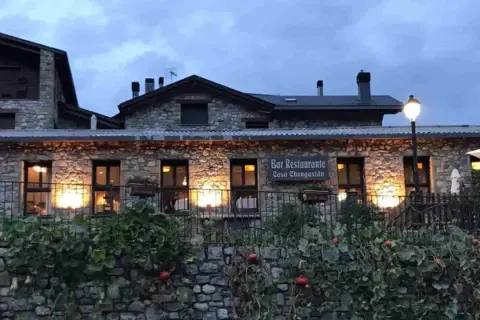 Casa Chongastán, un acogedor bar restaurante en Benasque, invita a cenar bajo la luz cálida de sus ventanas.