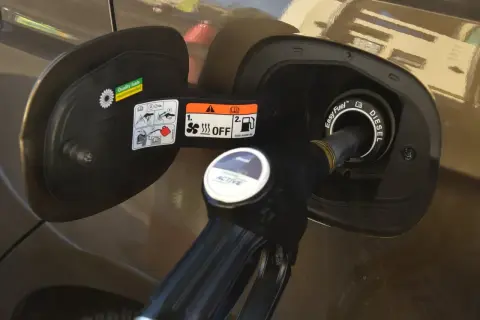 Dozbrań do baku diesla. Pistolet paliwowy wlewa paliwo do samochodu, pokazując, jak zatankować auto.