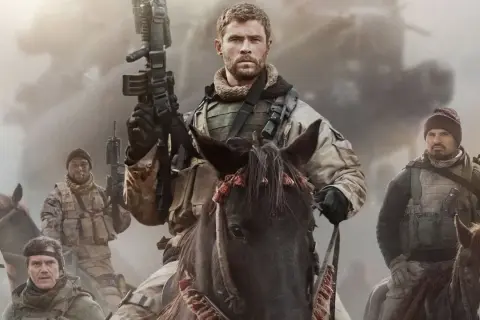 Chris Hemsworth leder en grupp soldater till häst i en actionfylld scen, typiskt för filmer med Chris Hemsworth.