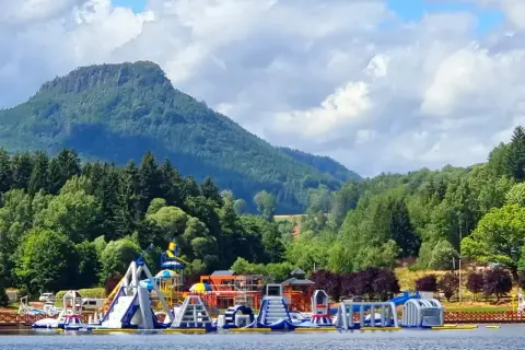 Kolorowy park wodny na **zalewie radkowskim** z górami w tle.