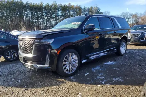 Czarny Cadillac Escalade 2025 z chromowanymi felgami i detalami, zaparkowany na żwirowym placu z resztkami śniegu.