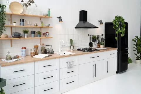 Cocina blanca y moderna con encimera de madera, campana negra y nevera retro. ¡Ideas para modernizar cocina sin obras!