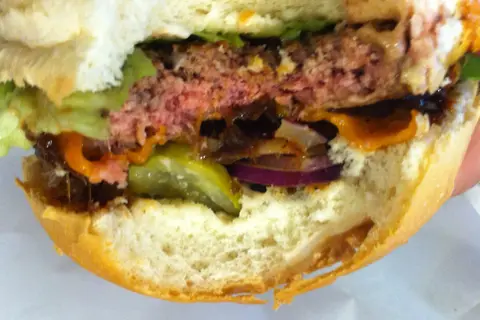 Soczysty burger z serem, sałatą, ogórkiem i cebulą. Idealny do podania po odpowiednim czasie smażenia.