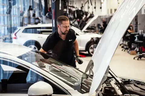 Mekaniker kontrollerar en bil i verkstad. För att bilen ska hålla sig i gott skick måste man serva bilen varje år.