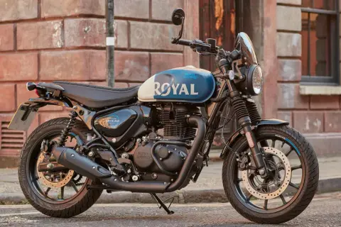 Stylowy motocykl Royal Enfield Hunter 350 z niebiesko-białym malowaniem zbiornika, zaparkowany na ulicy.