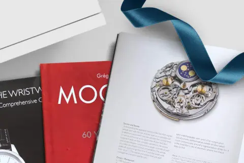 Libros de relojes con imágenes detalladas de mecanismos y cintas de satén.