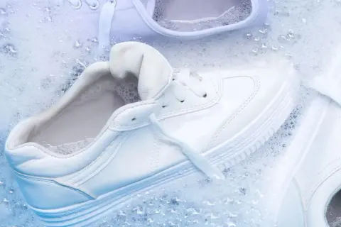 Come lavare le all star bianche: scarpe immerse in acqua e schiuma per un lavaggio impeccabile.