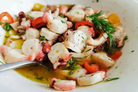 Ein köstlicher Pulpo Salat mit Tomaten und Dill in Olivenöl.