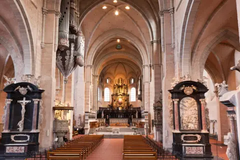 Innenansicht des Trierer Doms mit Orgel, Bänken und dem Hochaltar. Die dominformation trier ist beeindruckend.