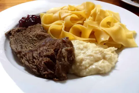 Ein Teller mit deftigem Braten, Bandnudeln, Klößen und Preiselbeeren – ein typisches Hochzeitsessen in Franken.