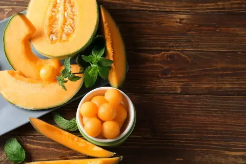Soczysty melon, pokrojony w plastry i kulki, z listkami mięty. Idealna przekąska, niskie melon kcal.