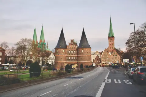 Holstentor, en ikonisk portbyggnad i norra Tyskland, med sina karaktäristiska torn och kyrkor i bakgrunden.