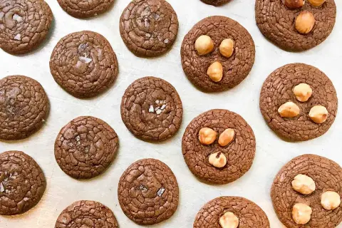 Mörka chokladkakor, några toppade med flingsalt, andra med hasselnötter. En härlig tryffelkaka mörk choklad för fikat.