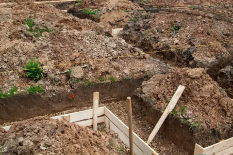 Wykopy pod fundamenty, przygotowane do wylania betonu. Zastanawiasz się, ile kosztuje kopanie fundamentów? To kluczowy etap budowy.