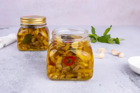 Melanzane sott'olio ricetta pugliese: vasetti pieni di sapore, con aglio e peperoncino.