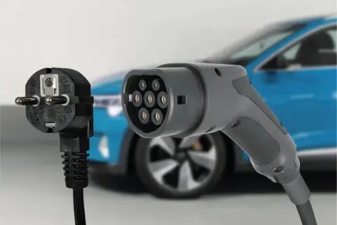 Wtyczka do ładowania samochodu elektrycznego i tradycyjny wtyk.
