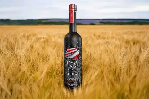 Butelka wódki Two Flags na tle złotego pola. Zastanawiasz się, ile kalorii ma setka wódki czystej?
