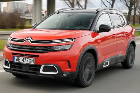 Czerwony Citroen C5 Aircross na drodze. Wiele pozytywnych citroen c5 aircross opinie potwierdza jego komfort i styl.